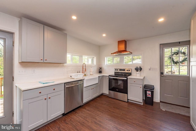 kitchen with extractor fan, a healthy amount of sunlight, appliances with stainless steel finishes, and dark hardwood / wood-style floors