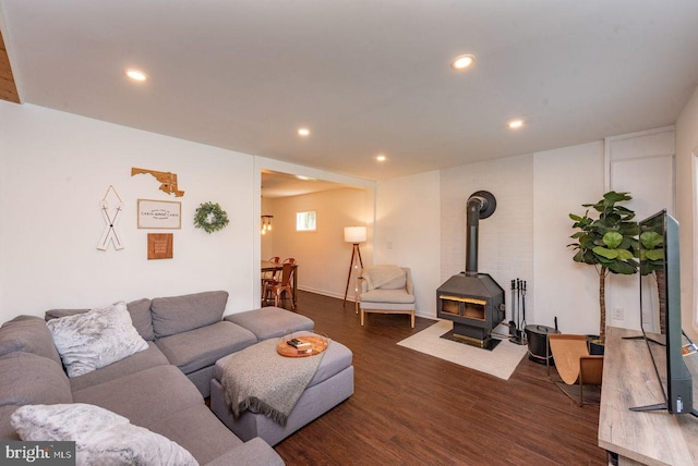 living room featuring dark hardwood / wood-style flooring and a wood stove