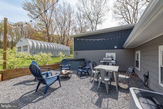 view of patio with central AC unit, a fire pit, and a grill