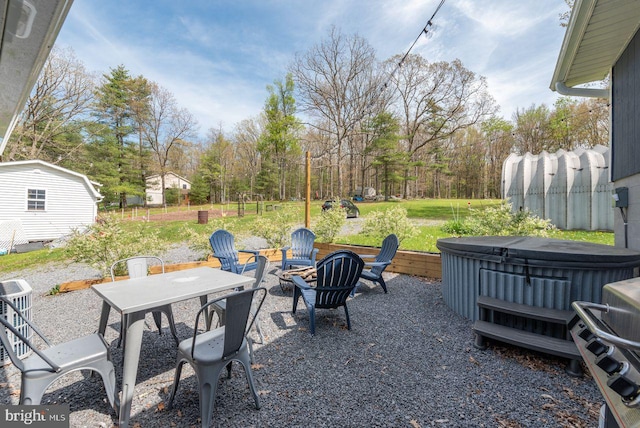 view of patio featuring an outdoor fire pit and a hot tub