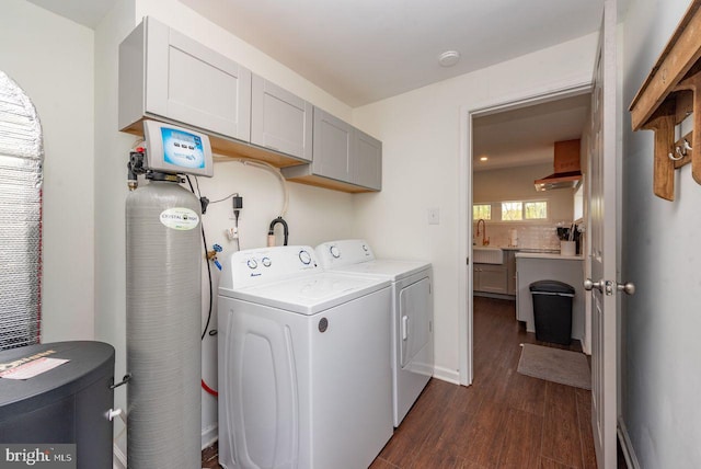 washroom featuring dark hardwood / wood-style flooring, cabinets, sink, and independent washer and dryer