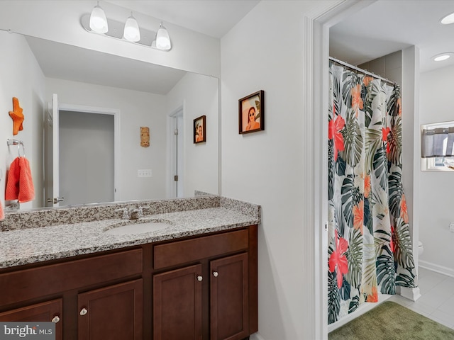 bathroom featuring toilet, vanity, and tile patterned floors