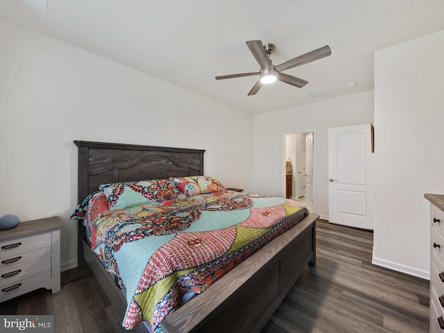 bedroom with ceiling fan, dark wood-type flooring, and connected bathroom