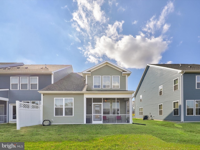 rear view of property with a sunroom, a yard, and central air condition unit