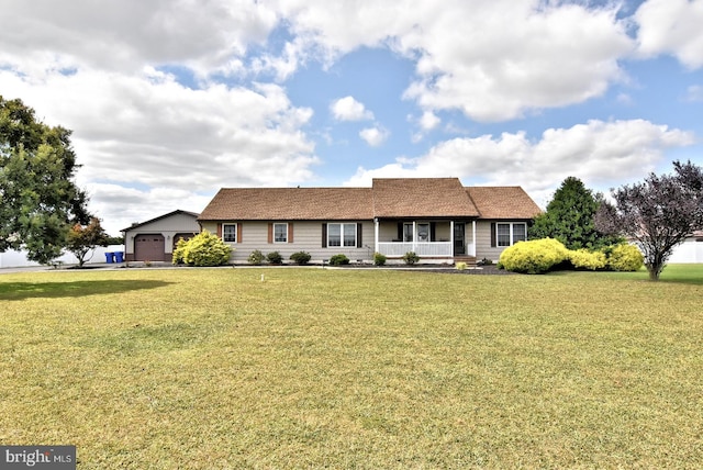 ranch-style home featuring a garage, a front yard, and covered porch