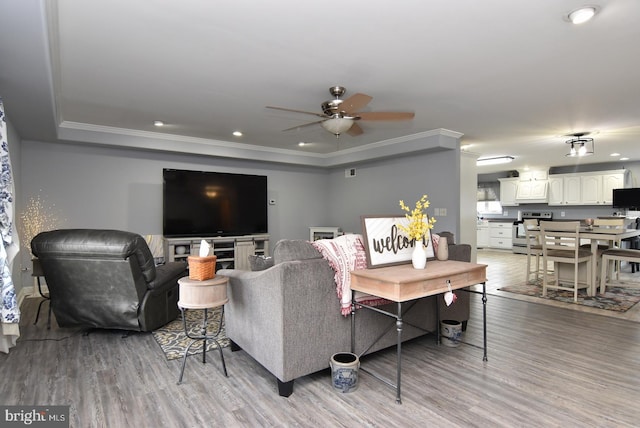 living room with ceiling fan, light hardwood / wood-style floors, and ornamental molding