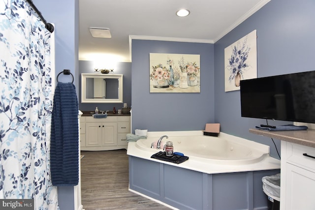 bathroom with hardwood / wood-style floors, a washtub, crown molding, and vanity