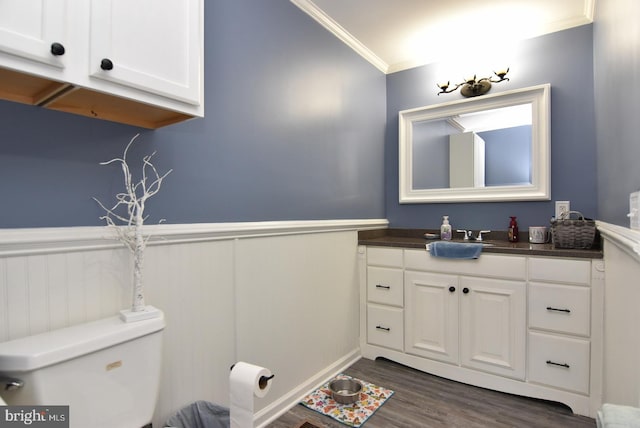 bathroom with ornamental molding, vanity, toilet, and hardwood / wood-style flooring