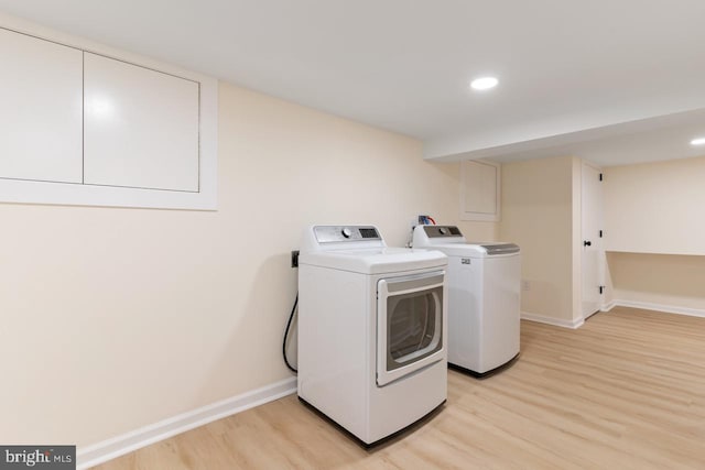 washroom featuring light wood-type flooring and washing machine and dryer