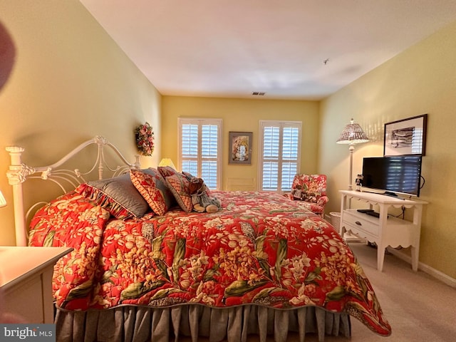 carpeted bedroom with visible vents and baseboards