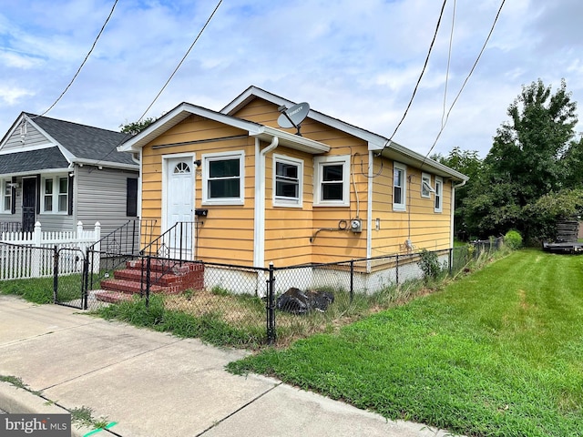 view of front of house with a gate, a fenced front yard, a front yard, and entry steps