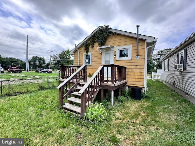 rear view of house with a lawn and a wooden deck