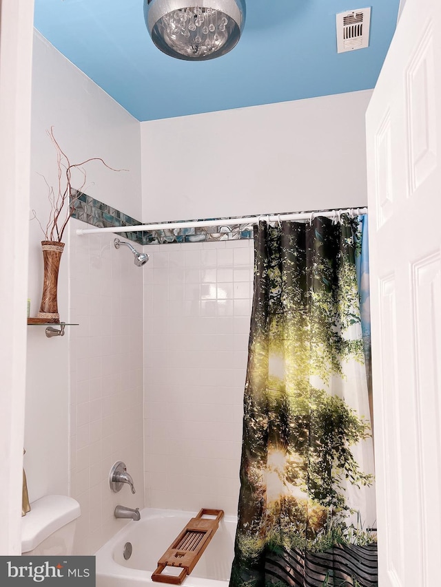 bathroom with shower / tub combo with curtain and toilet