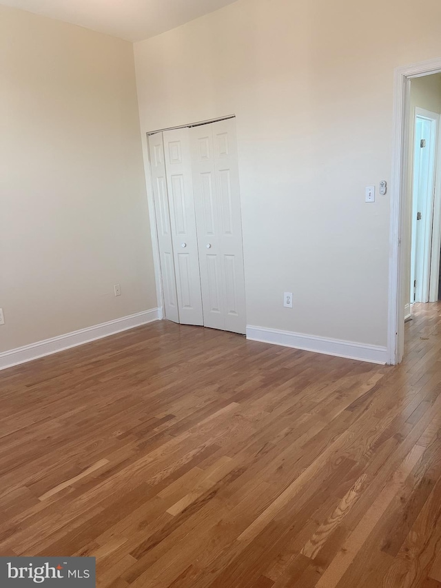 unfurnished bedroom featuring hardwood / wood-style flooring and a closet