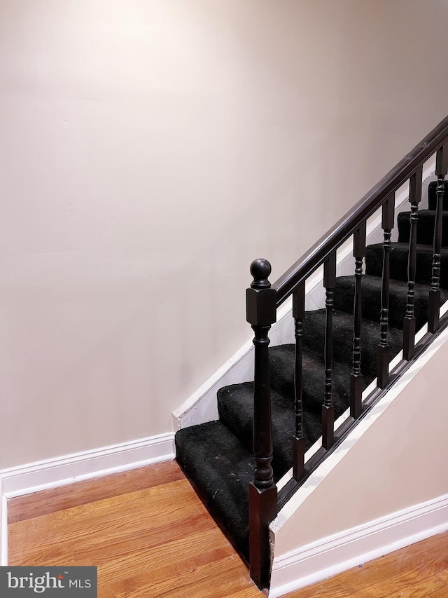 stairway with hardwood / wood-style floors