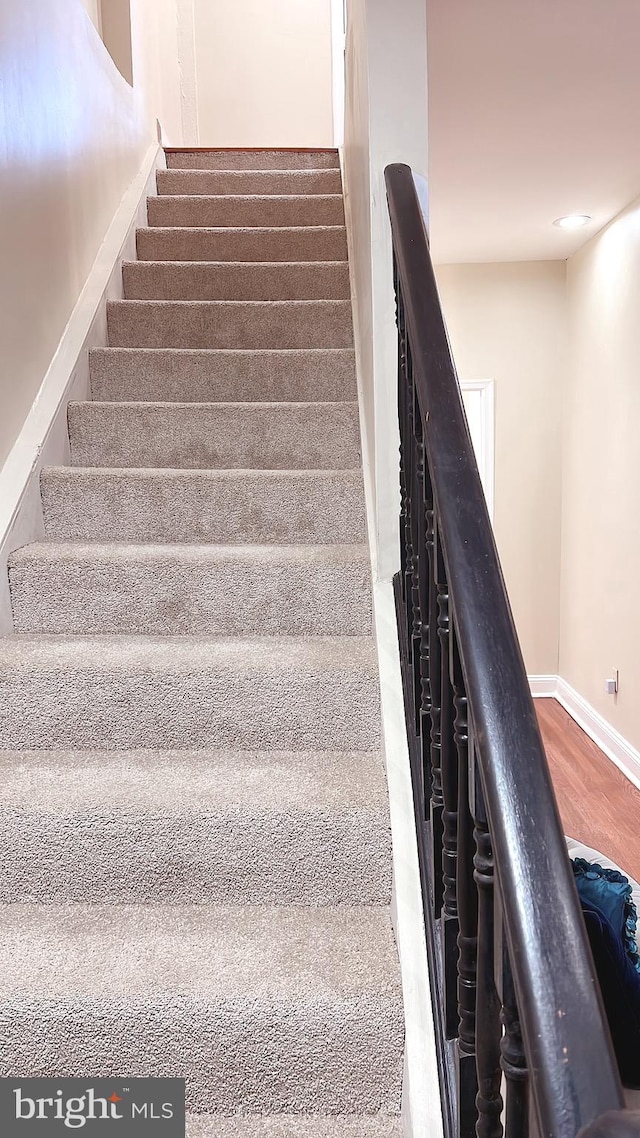 stairs featuring hardwood / wood-style floors