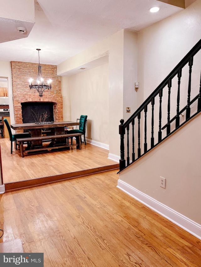 interior space with a chandelier, hardwood / wood-style floors, and a stone fireplace