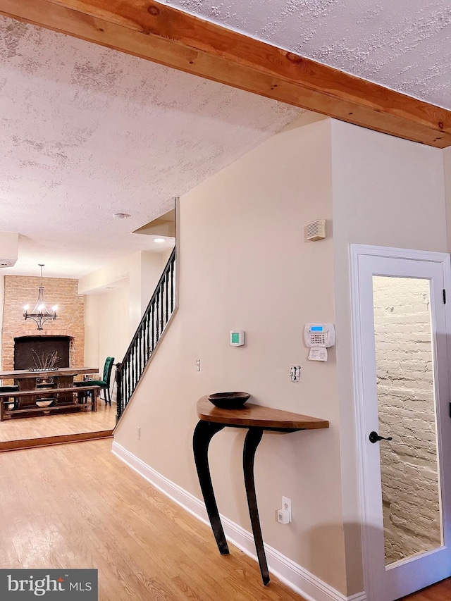 stairs featuring a fireplace, wood-type flooring, and a textured ceiling