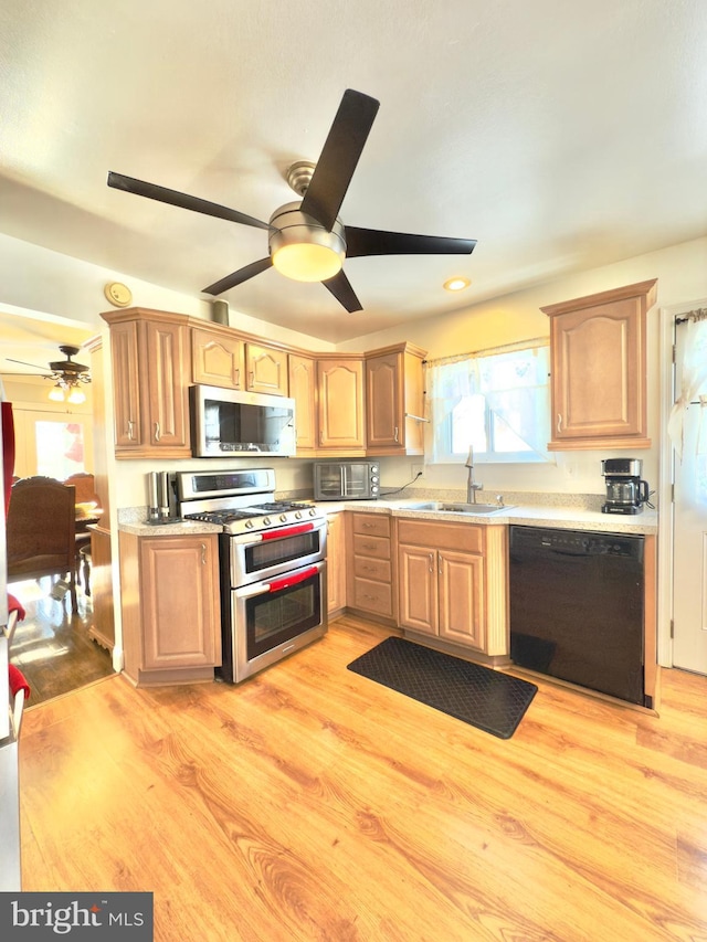 kitchen with ceiling fan, sink, light hardwood / wood-style flooring, and black appliances