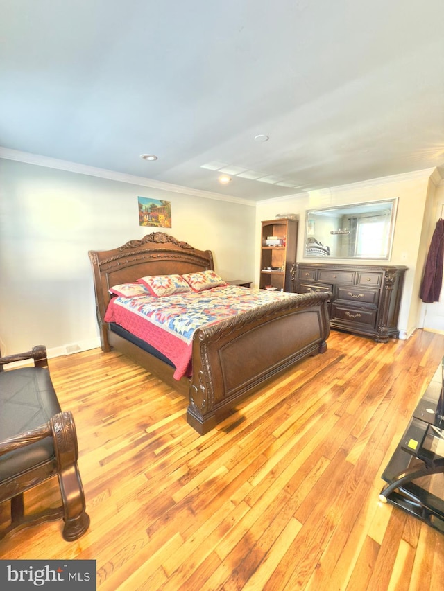 bedroom with ornamental molding and light wood-type flooring