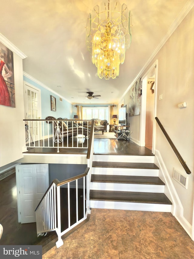 stairs with crown molding and ceiling fan with notable chandelier