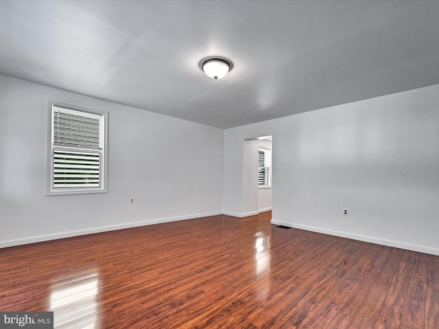 unfurnished room with dark wood-type flooring