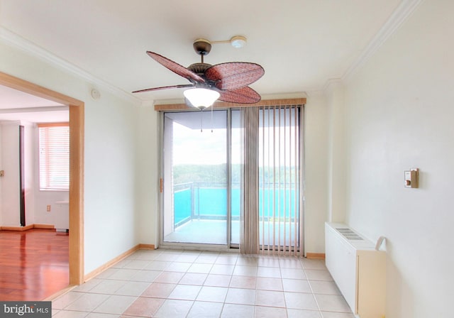 tiled spare room with ornamental molding, a wealth of natural light, ceiling fan, and radiator heating unit