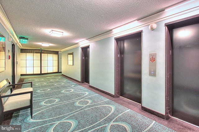 hallway featuring a textured ceiling and elevator