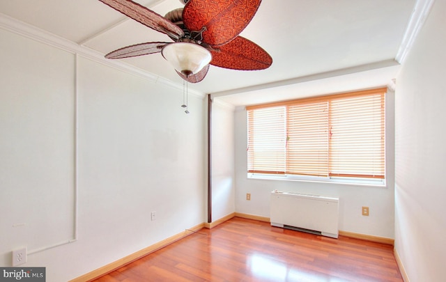 spare room with ornamental molding, radiator, hardwood / wood-style flooring, and ceiling fan