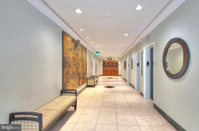 corridor with ornamental molding, elevator, and light tile patterned floors