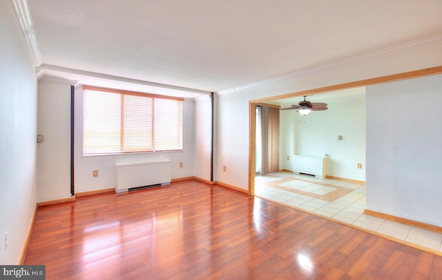 unfurnished room featuring light wood-type flooring, radiator, ornamental molding, and ceiling fan