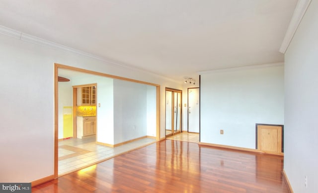 empty room featuring ornamental molding and light hardwood / wood-style flooring