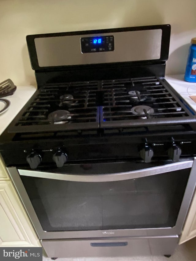 interior details featuring gas range and white cabinetry