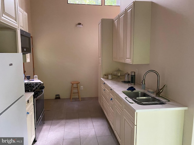 kitchen with white refrigerator, stainless steel gas stove, and sink