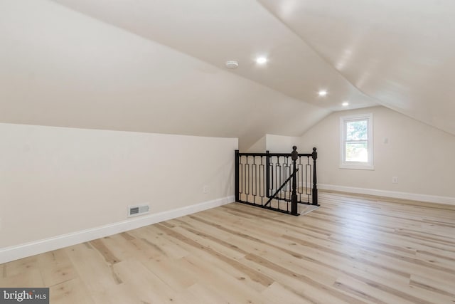 additional living space featuring lofted ceiling and light hardwood / wood-style floors