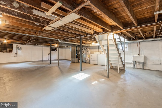 basement with gas water heater, sink, and washing machine and clothes dryer