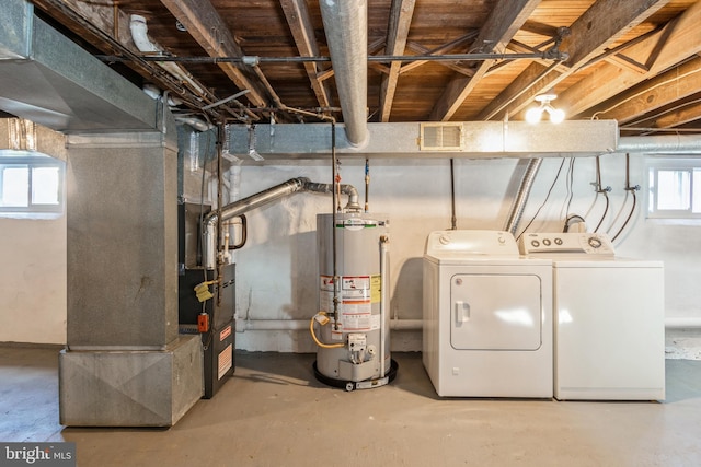 basement with water heater and washing machine and dryer