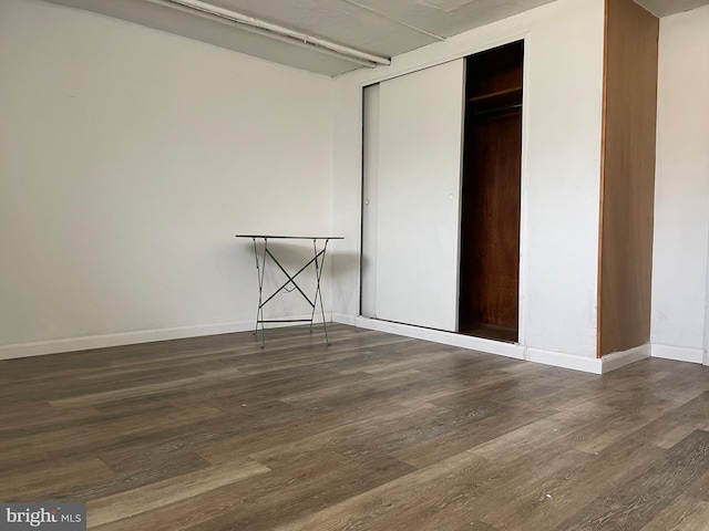 unfurnished bedroom with a closet and dark hardwood / wood-style flooring