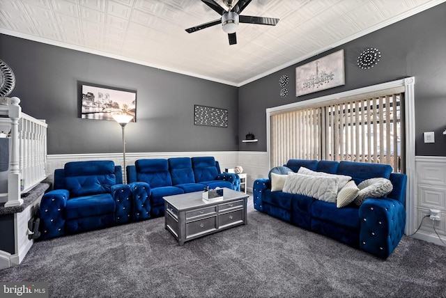 living room with ceiling fan, ornamental molding, carpet, and wainscoting