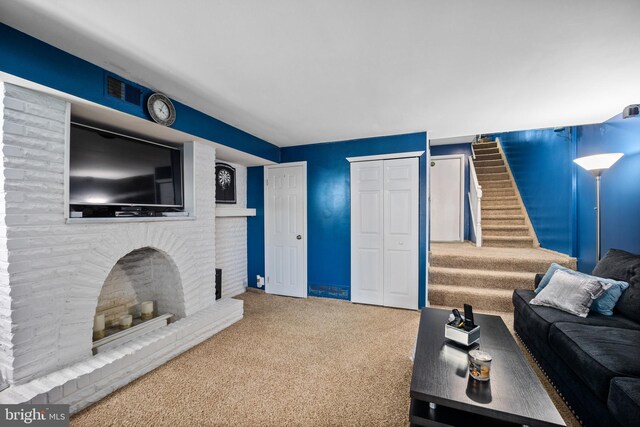 living room featuring carpet and a brick fireplace