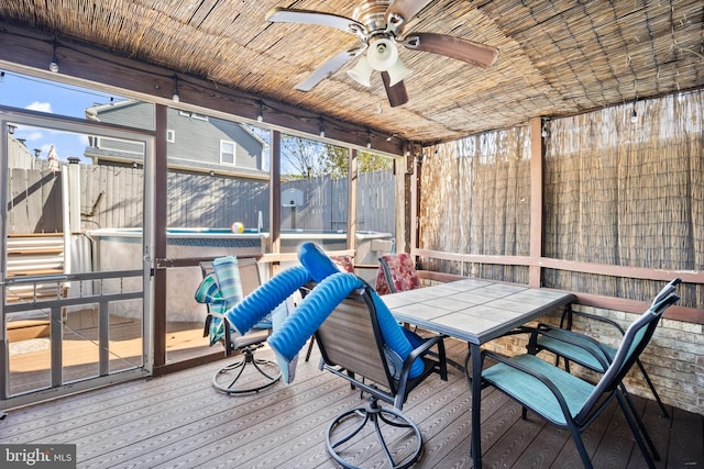 unfurnished sunroom featuring ceiling fan