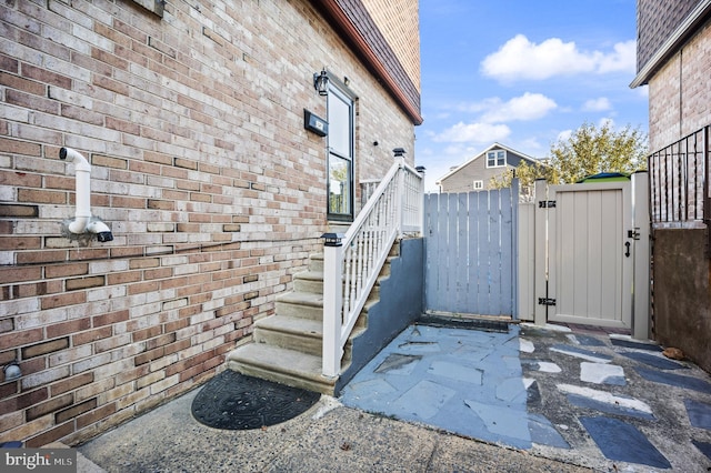 view of home's exterior with brick siding, fence, and a gate