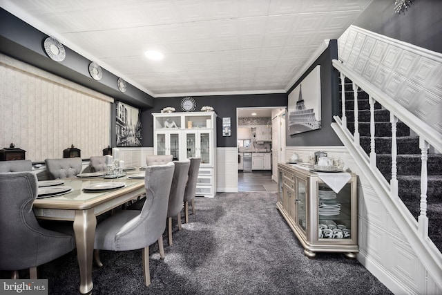 dining space with stairway, carpet, and wainscoting