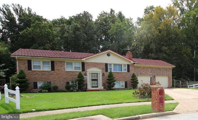 raised ranch featuring a front yard and a garage