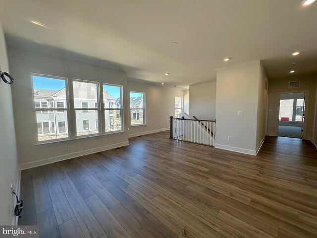 spare room featuring dark wood finished floors, visible vents, recessed lighting, and baseboards