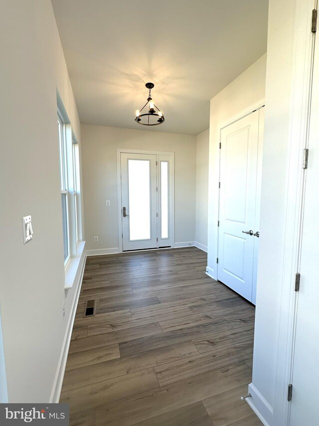 interior space with dark hardwood / wood-style flooring and a notable chandelier