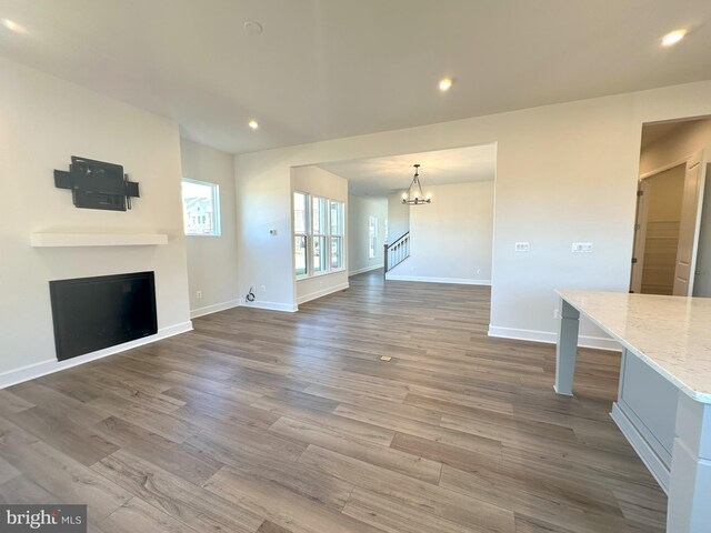 unfurnished living room featuring hardwood / wood-style flooring and a notable chandelier