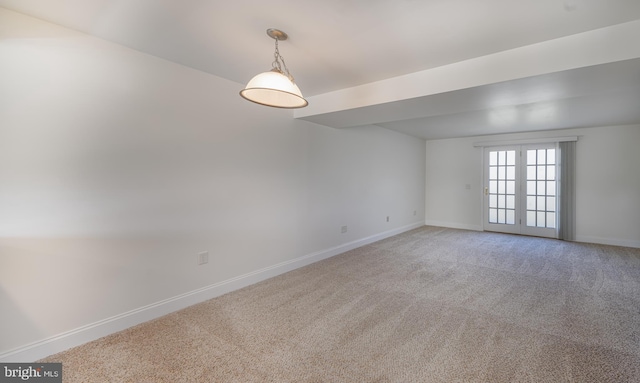 spare room featuring light carpet and baseboards