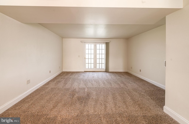 spare room with baseboards and carpet