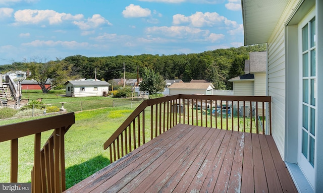 deck featuring a storage shed and a yard